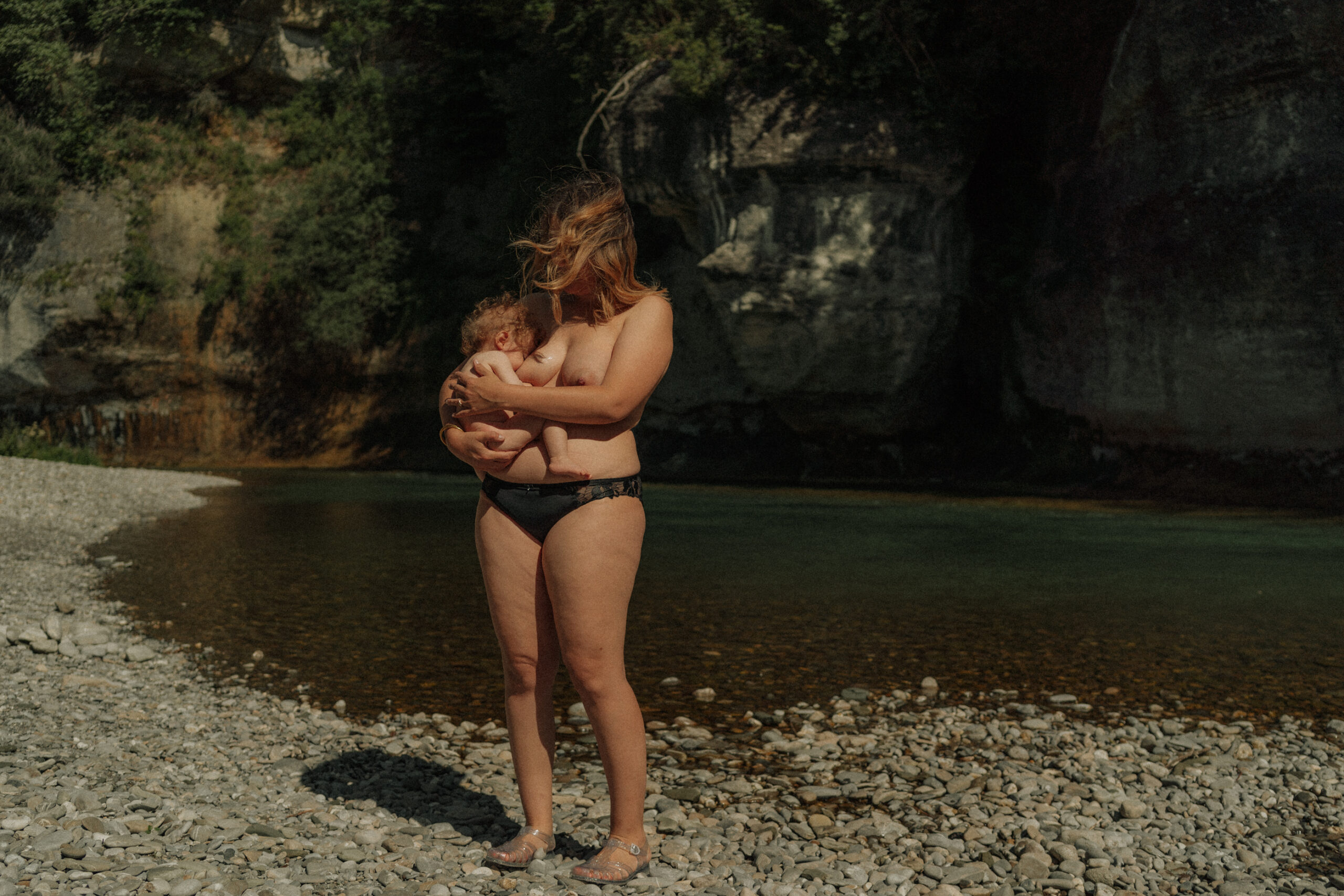 une m&egrave;re et sa fille en peau-&agrave;-peau au bord de la rivi&egrave;re