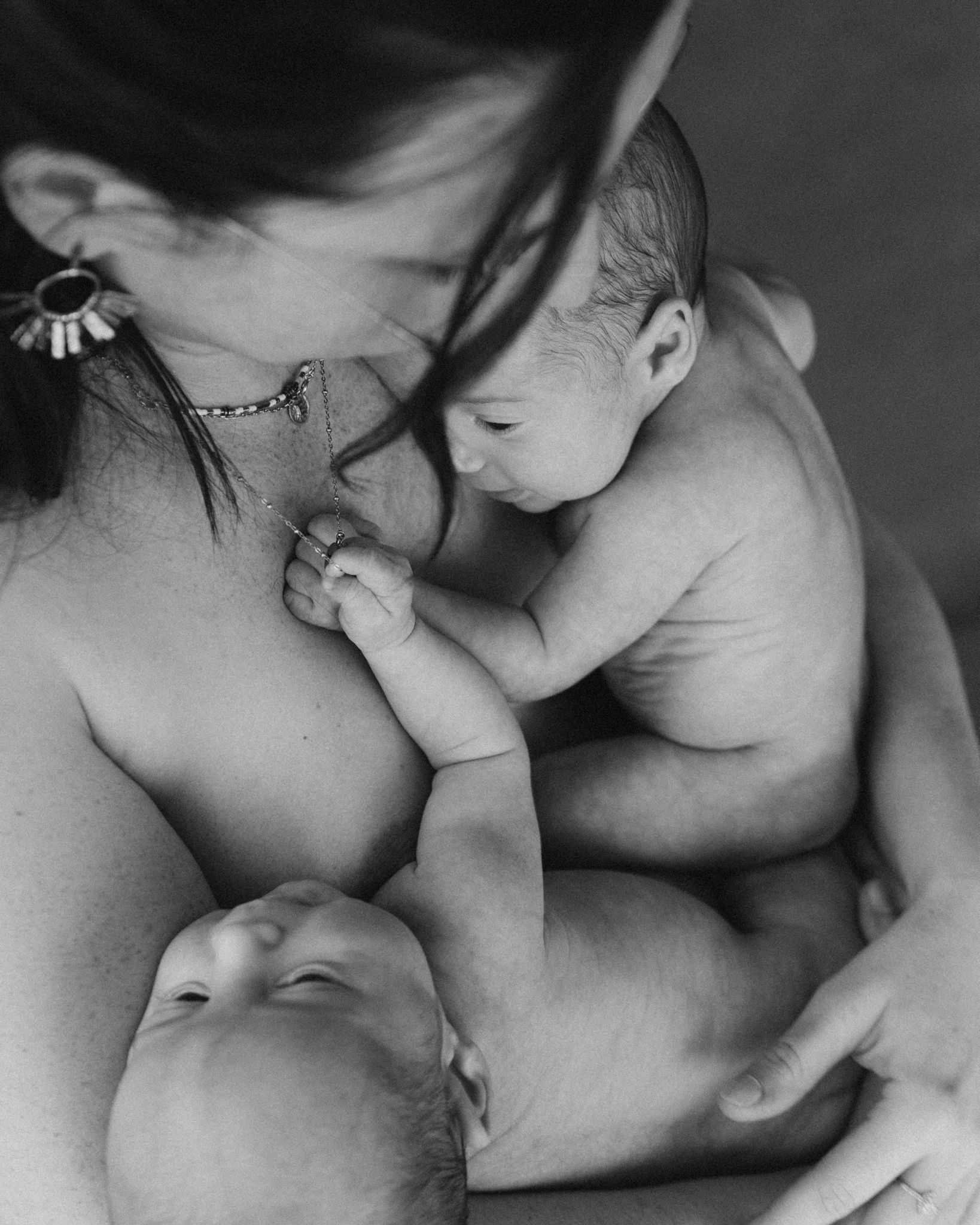 Une m&egrave;re qui porte ses jumeaux contre sa poitrine