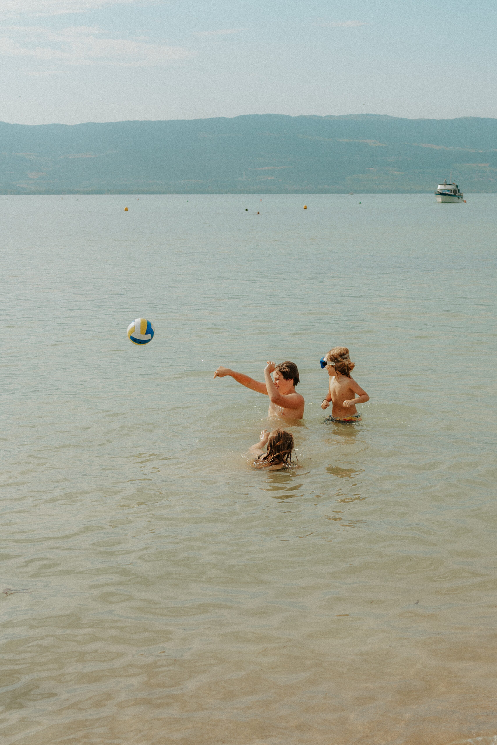 Une fratrie joue au balon dans un lac suisse
