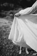 Une mère cache son enfant derrière sa robe