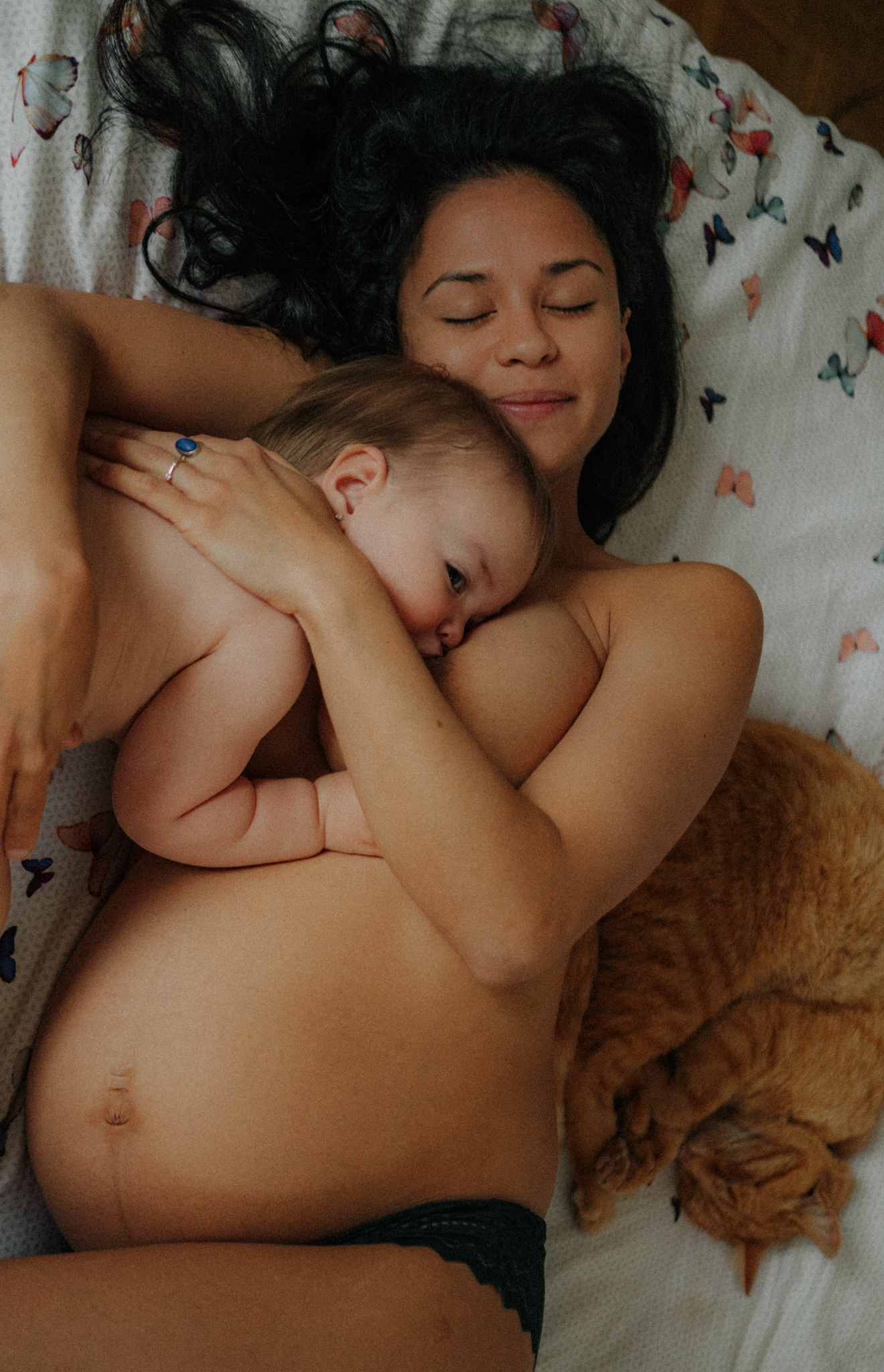 Une m&egrave;re allaite sa fille avec son chat &agrave; c&ocirc;t&eacute;