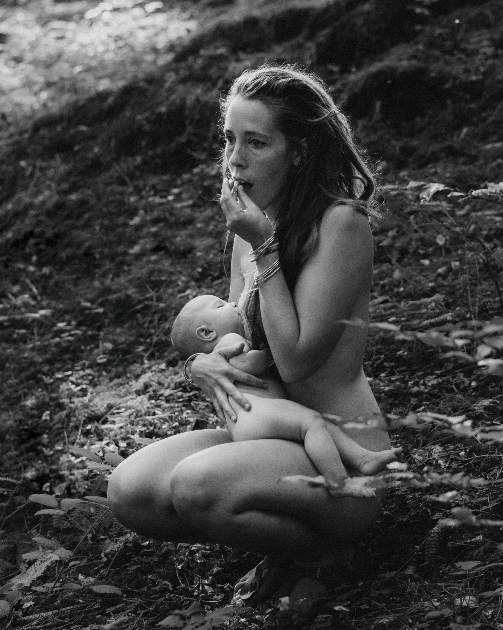 Femme qui allaite en for&ecirc;t nue en mangeant des baies