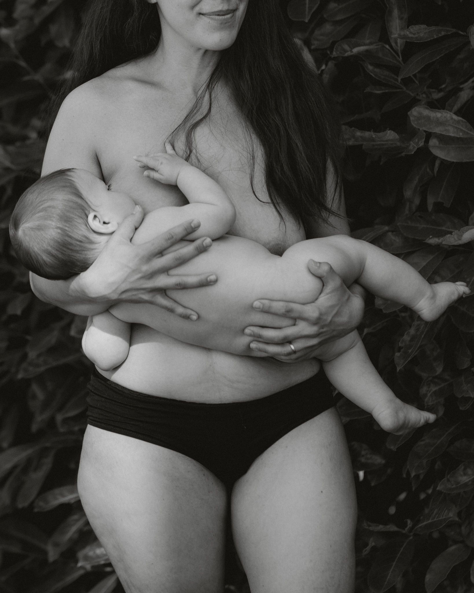 Une maman allaite en culotte dans son jardin