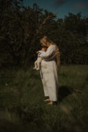 Une mère en post-partum porte son bébé dans son jardin